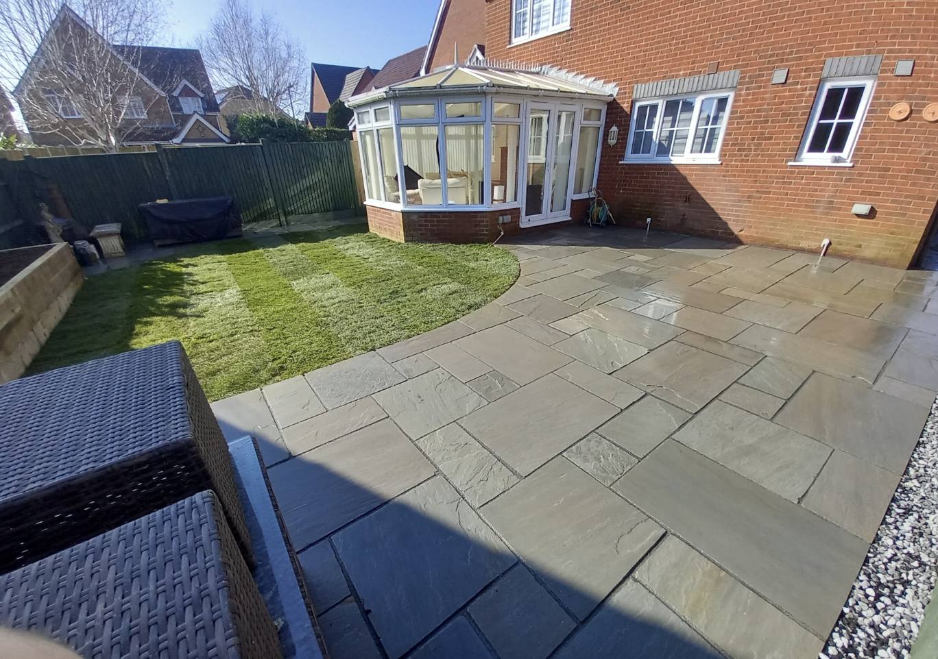 Sandstone patio wrapping around a conservatory in Kent