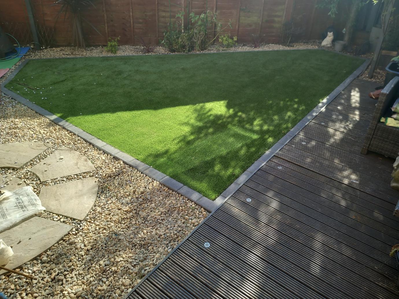 Artificial lawn with gravel and decking borders