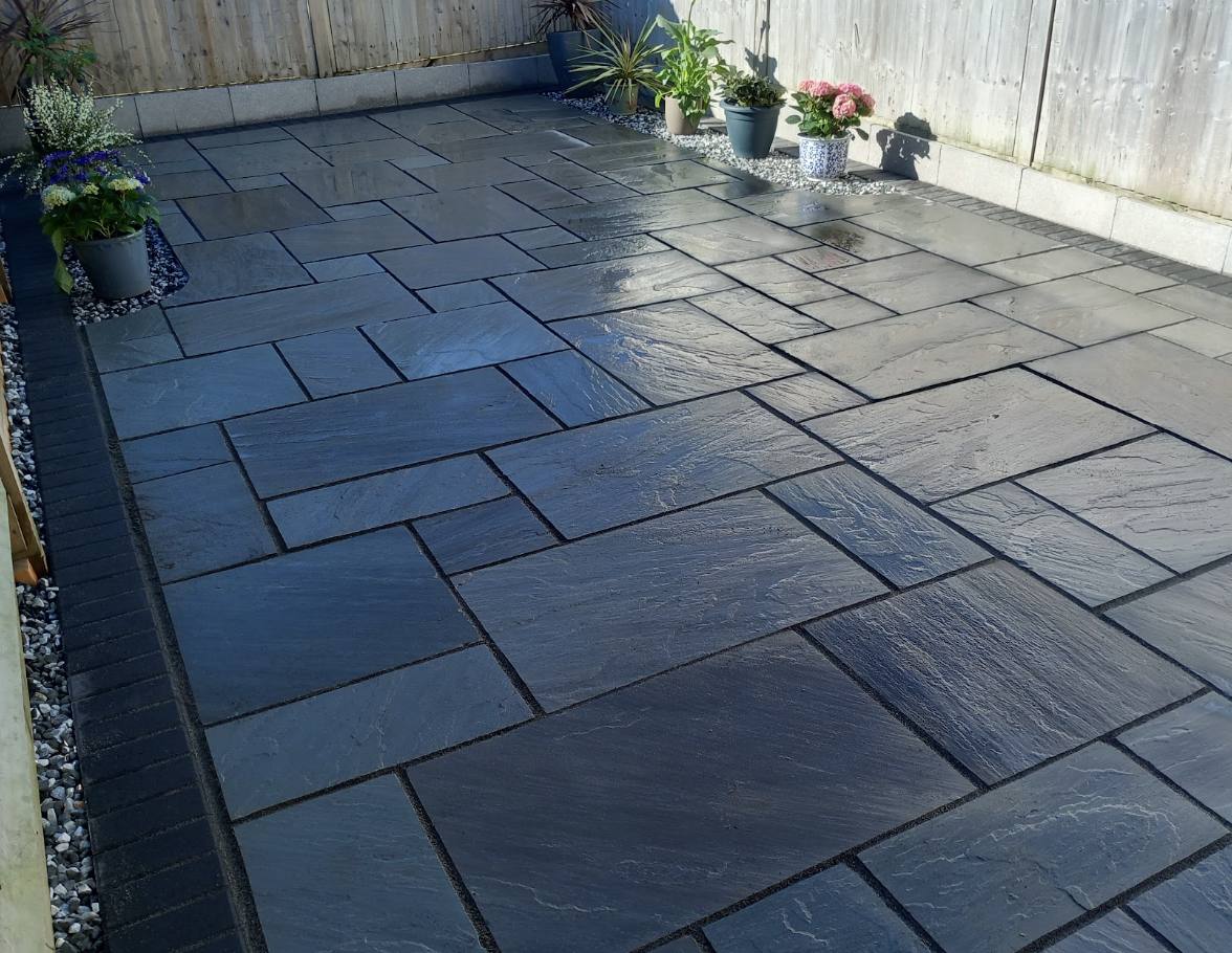 Dark slate patio seating area with planters