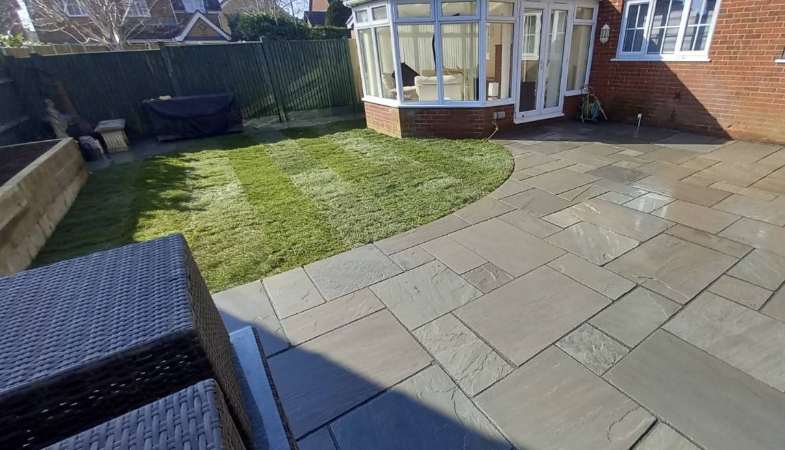 Fresh turf lawn curving around a conservatory